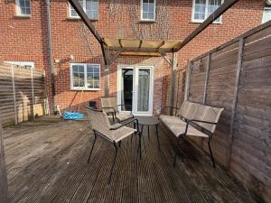 Dos sillas y una mesa en una terraza de madera. en Newbury House Long Stays Free Parking and Wifi, en Swindon