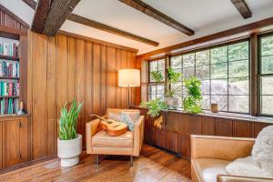 a living room with wood paneling and a chair and windows at Bedford Retreat 15 Mi to Long Island Sound in Bedford