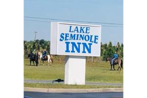 a sign that reads lakeennasembly inn with people riding horses at Lake Seminole Inn in Sneads