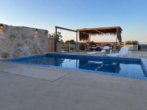 バトゥルーンにあるDomaine de Filiaの建物の隣にスイミングプール(テーブル、椅子付)