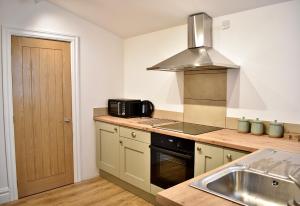 a kitchen with a sink and a microwave at Modern flat in South Yorkshire in Doncaster