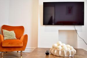 a living room with a chair and a television at Modern flat in South Yorkshire in Doncaster