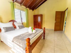a bedroom with a bed with two stuffed animals on it at Logement Solèy Rivyè- 3 chambres in Petit-Bourg