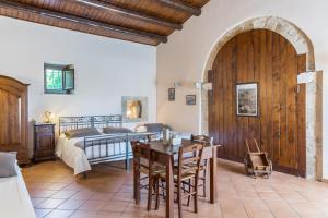 una camera con letto e tavolo con sedie di La Muraglia Residenza Turistica Rurale a Santa Croce Camerina