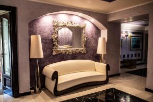 a living room with a chair and a mirror at Hotel Garibaldi in Milazzo