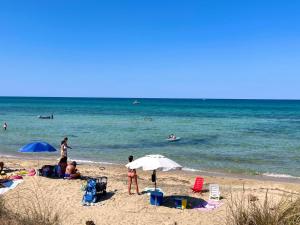 a group of people on a beach with the ocean at Villa Capitani in Torre Canne