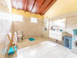 a bathroom with a shower toilet and a sink at Haut de villa Solèy Rivyè- 3 chambres in Petit-Bourg +14 photos