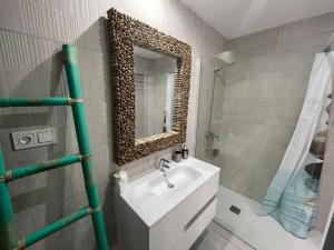 a bathroom with a sink and a mirror at MarVillaFuerte - Appart Air-Conditioned Swimming Pool & Private Jacuzzi in Villaverde