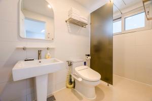 a bathroom with a toilet and a sink and a mirror at Hold in Hamdeok with beach in Jeju +58 photos