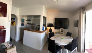a living room with a table and a kitchen at Magnifique Vue in Grimaud