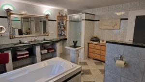 Un baño con bañera, lavabo y espejo. en Alpine Schmiede Chalet, en Ehrwald 25 fotos más