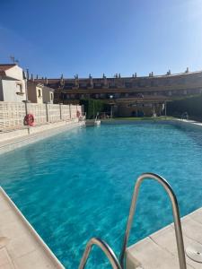 a large blue swimming pool with a bridge in the background at Dúplex Frente al Mar - Salobreña in Salobreña