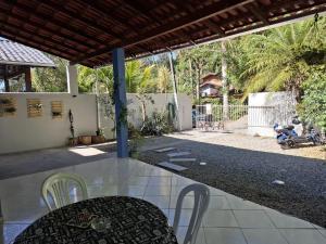 een terras met een tafel, stoelen en een hek bij Quarto Felicidade Cabeçudas in Itajaí +9 foto's
