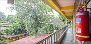 a building with a balcony with a tree on it at RadhaKrishna Stay IN in Arambol