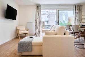a living room with a couch and a tv at Proche Lille - Terrasse - Charmant in Mons-en-Baroeul