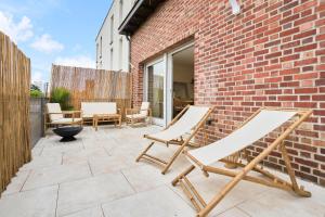 a patio with two chairs and a brick wall at Proche Lille - Terrasse - Charmant in Mons-en-Baroeul