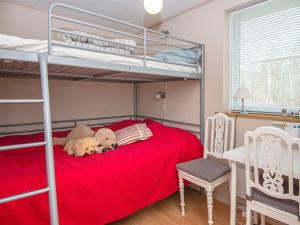 a bedroom with bunk beds with two teddy bears on a red bed at 8 person holiday home in Løgstør in Løgsted