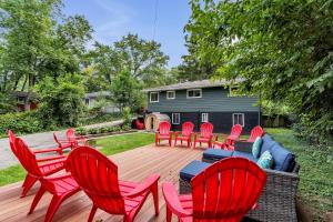 a deck with red chairs and a wooden table and bench at Serene Suburban Oasis 2 Saunas, Office, Parking in Ann Arbor