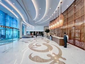 a lobby of a building with a spiral design on the floor at GYL Holiday Homes -Imperial Avenue - Luxury Retreat Apt with Burj Khalifa Pool View - Near Dubai Mall in Dubai +46 photos