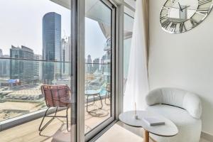 a living room with a large window with a clock at GYL Holiday Homes -Imperial Avenue - Luxury Retreat Apt with Burj Khalifa Pool View - Near Dubai Mall in Dubai