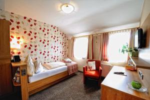 a bedroom with a bed and a chair in a room at Landhotel Talblick in Neuweiler +76 photos