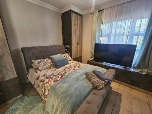 a bedroom with a bed and a flat screen tv at Family Home with Entertainment Area in Westville