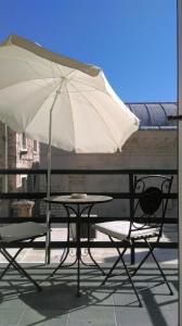 a table and two chairs and an umbrella on a balcony at Diocletian's Palace Apartments in Split