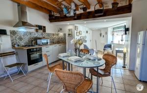 a kitchen and dining room with a table and chairs at Le Brocangîte à Jules in Bèze