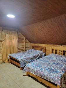 a bedroom with two beds and a ceiling at La Yeguada - Forest Point Cabin in El Quije