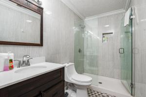 a bathroom with a shower and a toilet and a sink at American Pharaoh Twin Spires Suite in Jeffersonville +33 photos