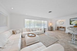 a living room with a white couch and a table at Bimini Breeze - Updated Island Retreat with Pool & Beach Access in West Palm Beach
