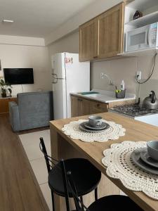 a kitchen with a table with chairs and a refrigerator at Apartamento Pelotas in Pelotas +12 photos