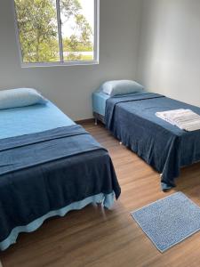 a bedroom with two beds and a window at Apartamento Pelotas in Pelotas