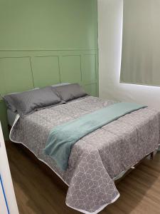 a bedroom with a bed with a green headboard at Apartamento Pelotas in Pelotas