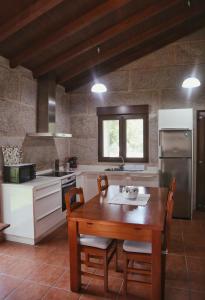 a kitchen with a wooden table with chairs and a stove at Vilaboa Paradise in Villanueva