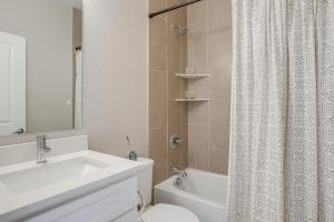 ein Badezimmer mit Waschbecken, Toilette und Duschvorhang in der Unterkunft Rooftop Deck and Hot Tub Walkable Denver Townhome in Denver + 27 Fotos