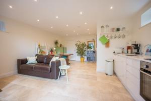a living room with a couch and a kitchen at Sedge Cottage "Barn", Reydon in Reydon
