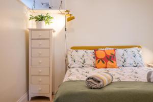 a small bedroom with a bed and a dresser at Sedge Cottage "Barn", Reydon in Reydon