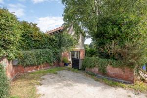 a brick house with a brick wall and trees at Sedge Cottage "Barn", Reydon in Reydon