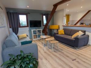 a living room with a couch and a table at Le Moment Normand in Émalleville