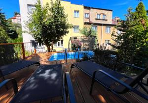 a deck with two benches and a swimming pool at Apartment Sport & Sauna Prague in Prague +11 photos