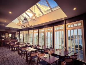 a dining room with tables and chairs and windows at Churchill Hotel Bayeux Centre in Bayeux +77 photos
