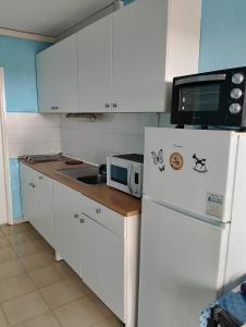 a kitchen with a white refrigerator and a microwave at Casa Ventura in Costa de Antigua