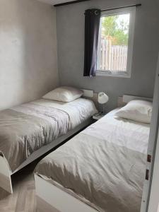 due letti in una camera da letto con finestra di Le Refuge sablais a Les Sables-dʼOlonne