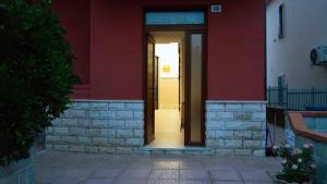 an entrance to a building with a red wall at Il piccolo tempio di Ely in Termoli +23 photos