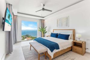 a bedroom with a bed and a large window at Luxury Oceanview Condo with Pool in Tamarindo