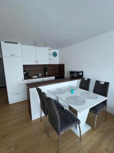 Una cocina blanca con una mesa y sillas blancas. en Sursilvana 18 (317 Ma), en Lenzerheide