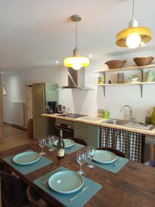 a kitchen with a table with plates and wine glasses at Le Chablis'cîmes in Champagnole