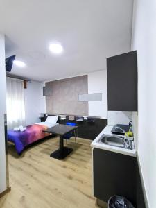 a room with a bed and a kitchen with a sink at Affittacamere Ai Pila in Montebelluna +23 photos