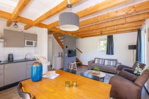 a kitchen and a living room with a wooden ceiling at Gezellige Zeeuwse Cottage voor 4 personen in Wemeldinge +11 photos